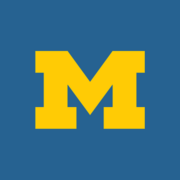 Blue background with a large, bold yellow letter "M" centered. The image conveys a sense of school spirit and tradition.